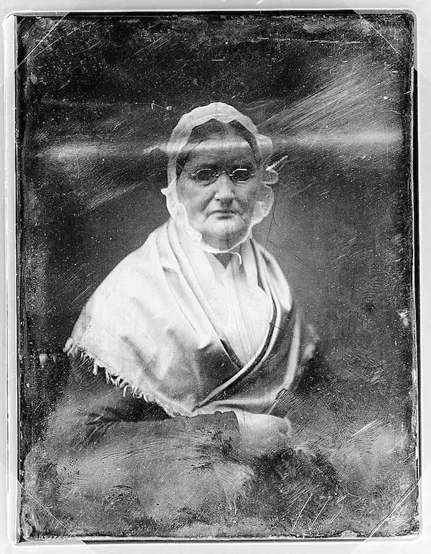 Torn vintage portrait of elderly woman beautifully restored through AI old photo restoration