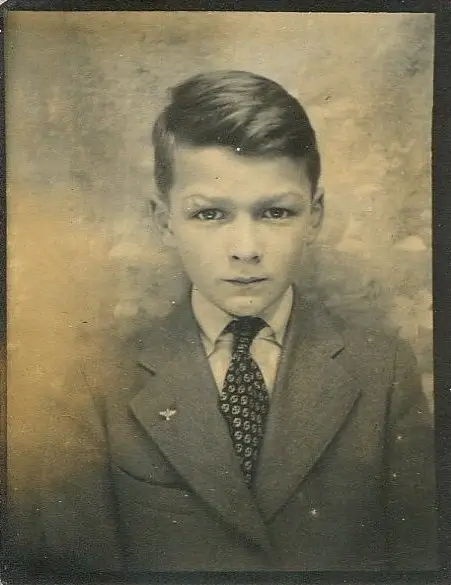 Vintage black and white photo of boy in suit colorized with professional AI photo colorizer